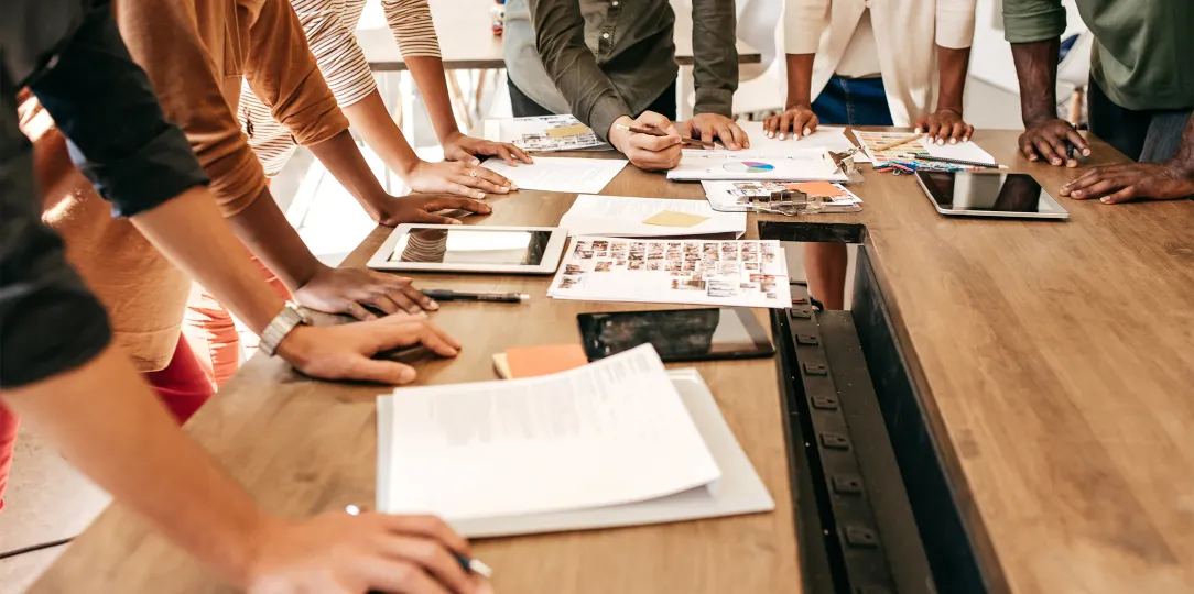 group of workers standing over the desk