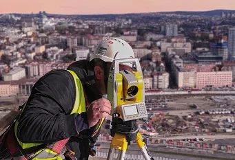 worker with conventional topographic survey equipment